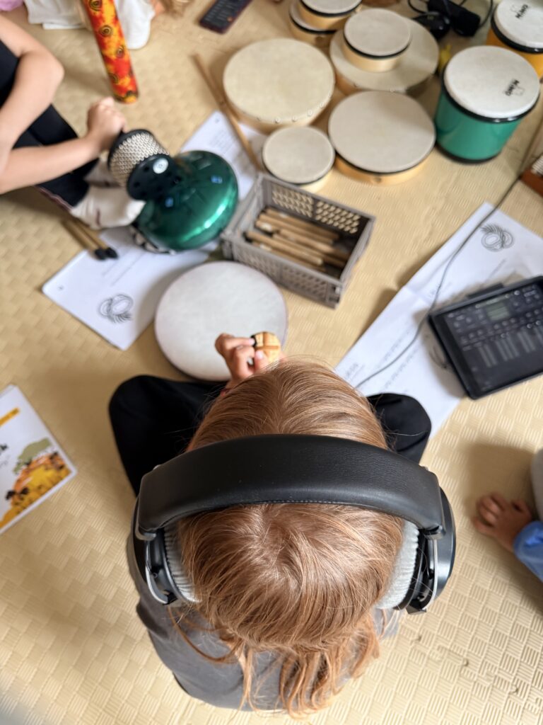 Dziecko słuchające muzyki i tworzące muzykę elektroniczną podczas Wakacyjnych Warsztatów Muzycznych